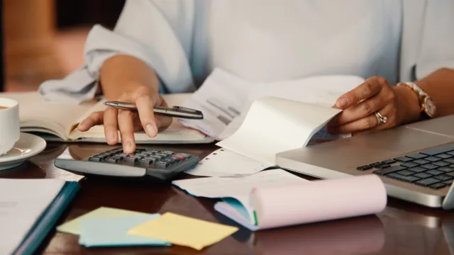 Fotografia de uma pessoa digitando em uma calculadora